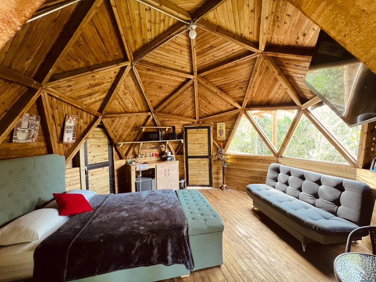 Interior de un domo geodésico de madera con acabado rústico
